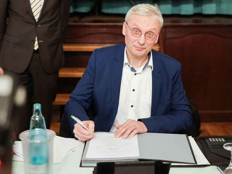 Kai Uwe Evers, der Bürgermeister von Norderwöhrden, unterzeichnet einen Durchführungsvertrag. - Foto: Christian Charisius/dpa