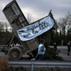 Landwirte kippen Zweige und Äste auf die Fahrbahn, während sie eine Autobahn in der Nähe von Lyon blockieren. - Foto: Laurent Cipriani/AP/dpa