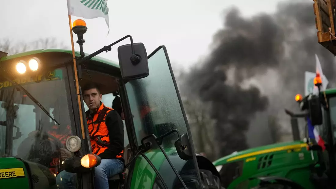 Franzöische Landwirte blockieren einen Kreisverkehr. - Bild: Thibault Camus/AP/dpa