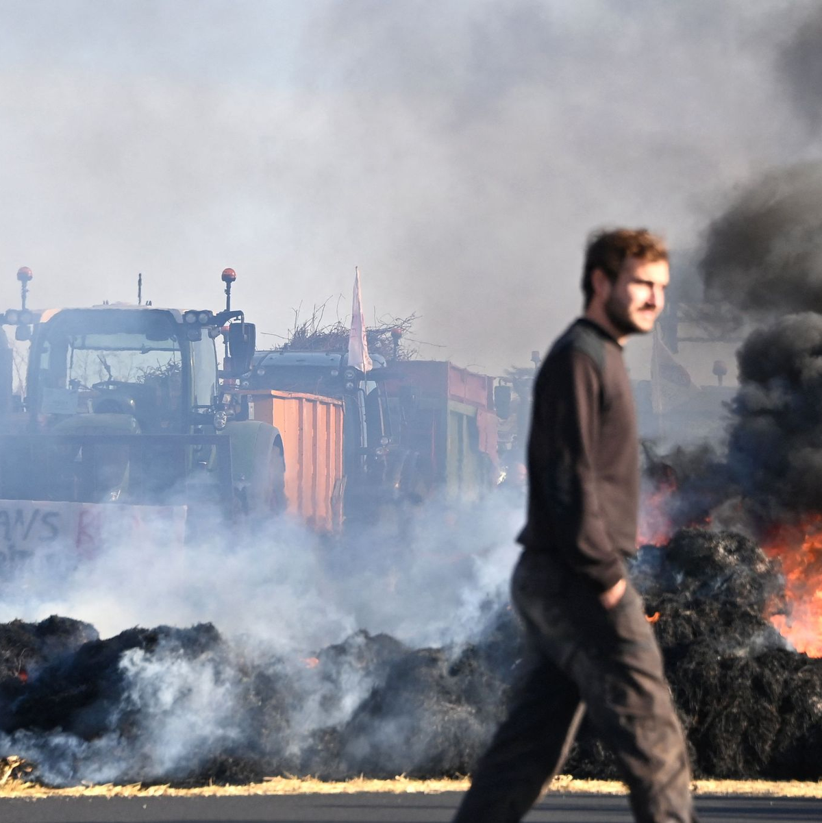 Französische Landwirte verbrennen Strohballen, während sie die Autobahn A9 in der Nähe von Montpellier blockieren. - Foto: Sylvain Thomas/AFP/dpa