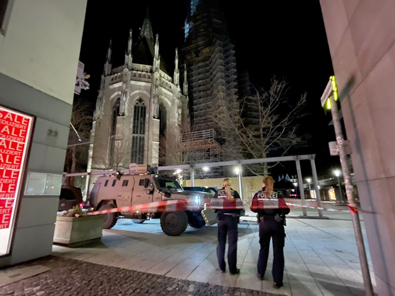 Zwei Polizistinnen stehen hinter einem Absperrband der Polizei am Münsterplatz. - Foto: Nico Pointner/dpa