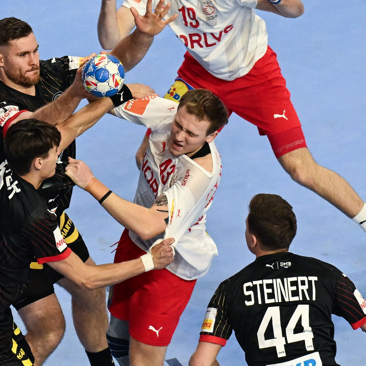 Das deutsche Innenblock-Duo Johannes Golla (oben, l) und Julian Köster verteidigt gegen den Dänen Simon Pytlick. - Foto: Federico Gambarini/dpa