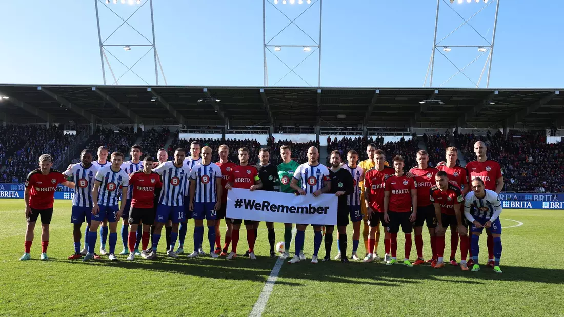 Die Teams von Hertha BSC und SV Wehen Wiesbaden gedenken gemeinsam an die Opfer des Nationalsozialismus. - Bild: Jörg Halisch/dpa