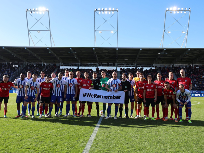 Die Teams von Hertha BSC und SV Wehen Wiesbaden gedenken gemeinsam an die Opfer des Nationalsozialismus. - Foto: Jörg Halisch/dpa