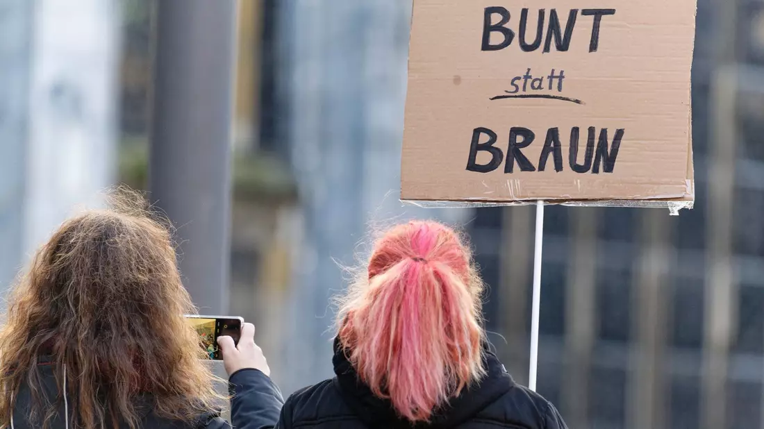 «Bunt statt braun»: Diese beiden Frauen sind in Aachen gegen Rechtsextremismus auf die Straße gegangen. - Bild: Henning Kaiser/dpa
