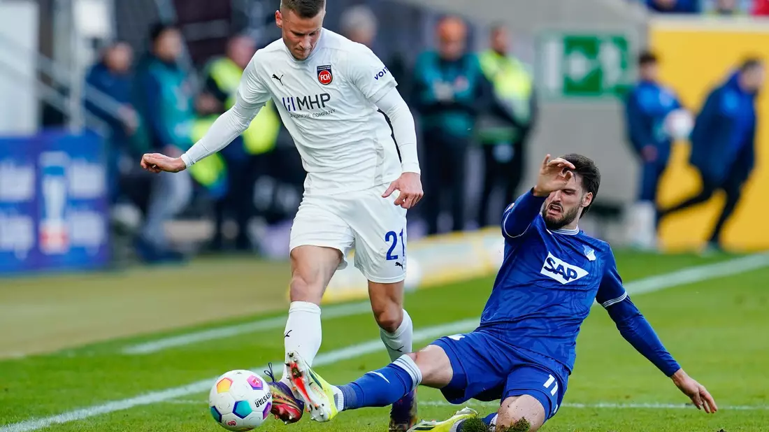 Der 1. FC Heidenheim um Niklas Dorsch (r) und die TSG 1899 Hoffenheim um Valentin Gendrey lieferten sich ein Duell auf Augenhöhe. - Bild: Uwe Anspach/dpa