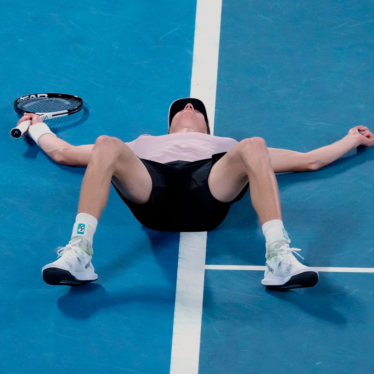 Jannik Sinner lässt sich nach seinem Triumph bei den Australian Open auf den Platz fallen. - Foto: Mark Baker/AP/dpa