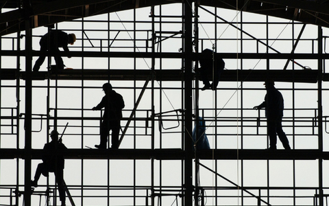 Arbeiter montieren auf einem Gerüst die Glasfassade des Bahnhofs von Frankfurt am Main. - Foto: picture alliance / dpa