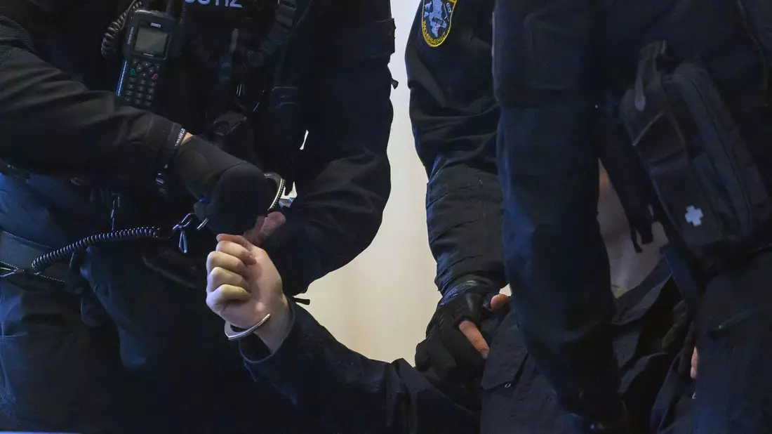 Justitzbeamte nehmen dem Angeklagten im Gerichtssaal vom Landgericht Magdeburg die Handschellen ab. - Bild: Klaus-Dietmar Gabbert/dpa