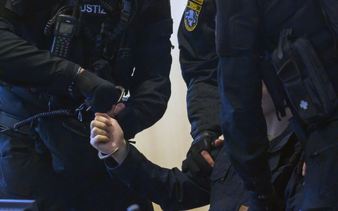 Justitzbeamte nehmen dem Angeklagten im Gerichtssaal vom Landgericht Magdeburg die Handschellen ab. - Foto: Klaus-Dietmar Gabbert/dpa