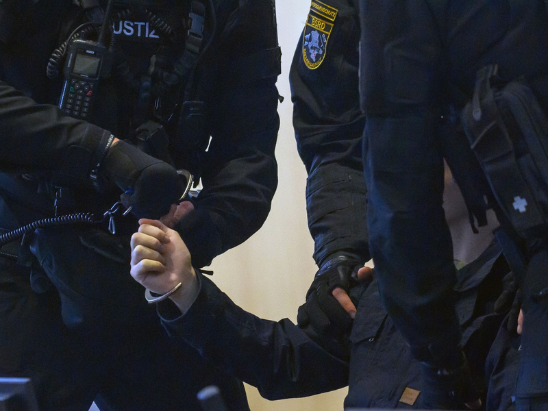 Justitzbeamte führen den Angeklagten in den Gerichtssaal in Magdeburg. - Foto: Klaus-Dietmar Gabbert/dpa