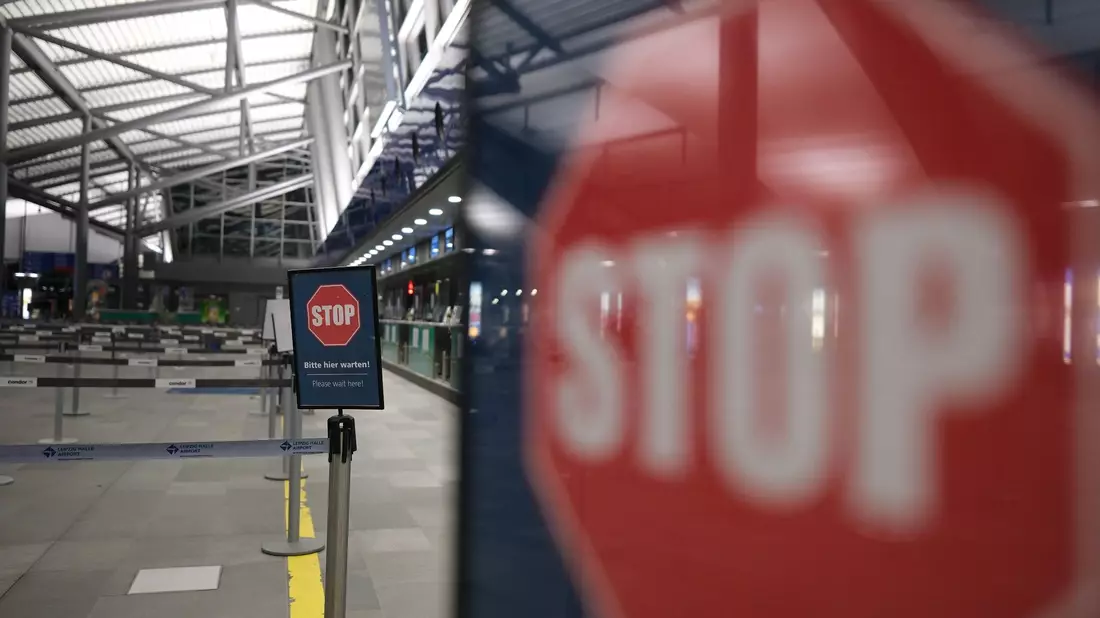 Stop-Schilder in einer leeren Flughafen-Halle. - Bild: Sebastian Willnow/dpa