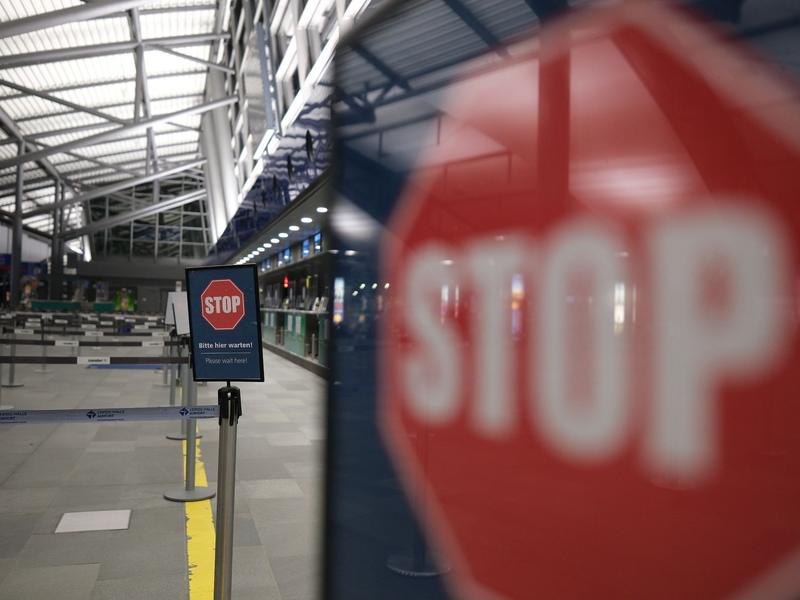 Stop-Schilder in einer leeren Flughafen-Halle. - Foto: Sebastian Willnow/dpa