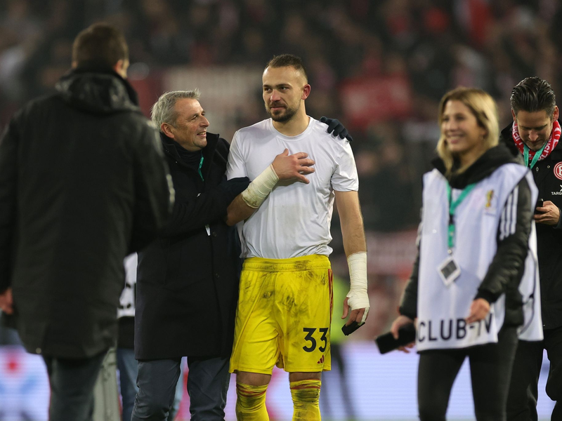 Klaus Allofs (2.v.l.) gratuliert Fortuna-Torwart Florian Kastenmeier zum Sieg. - Foto: Christian Charisius/dpa