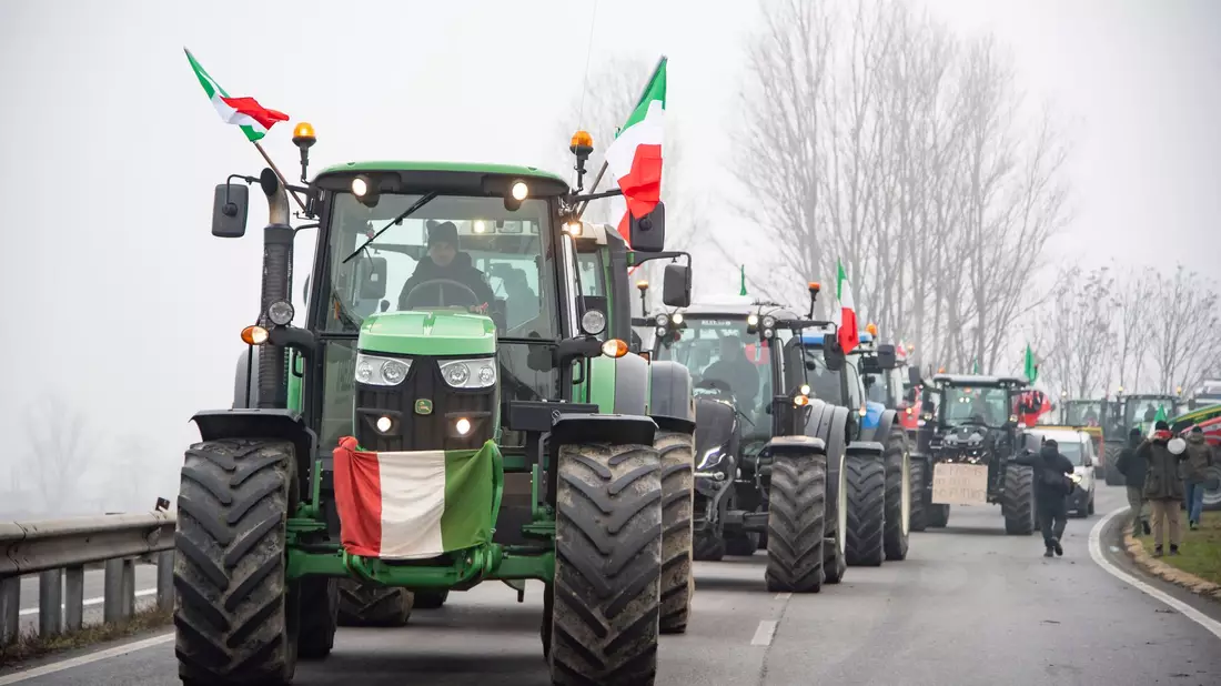 Landwirte fahren mit ihren Traktoren eine Straße an der Mautstelle von Melegnano in der Nähe von Mailand entlang. - Bild: Claudio Furlan/LaPresse/dpa