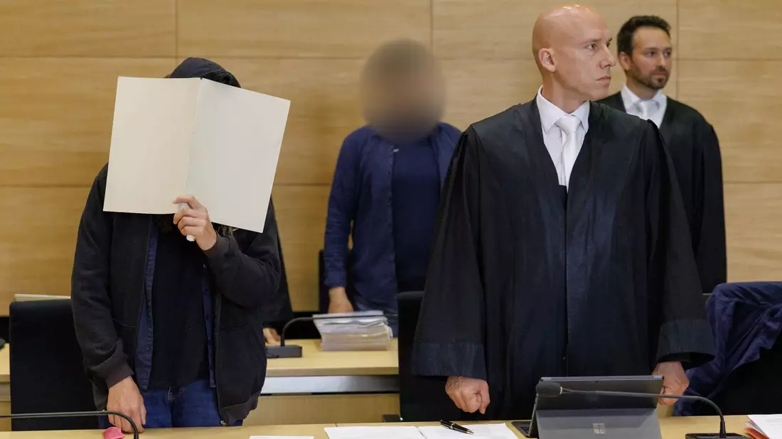 Die Angeklagten im Landgericht Bielefeld neben ihren Rechtsanwälten. - Bild: Friso Gentsch/dpa