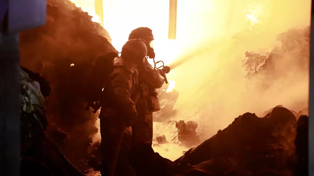 Feuerwehrleute löschen ein Feuer, das durch die Explosion des mit Gaszylindern beladenen Lastwagens verursacht wurde. - Bild: John Ochieng/AP/dpa