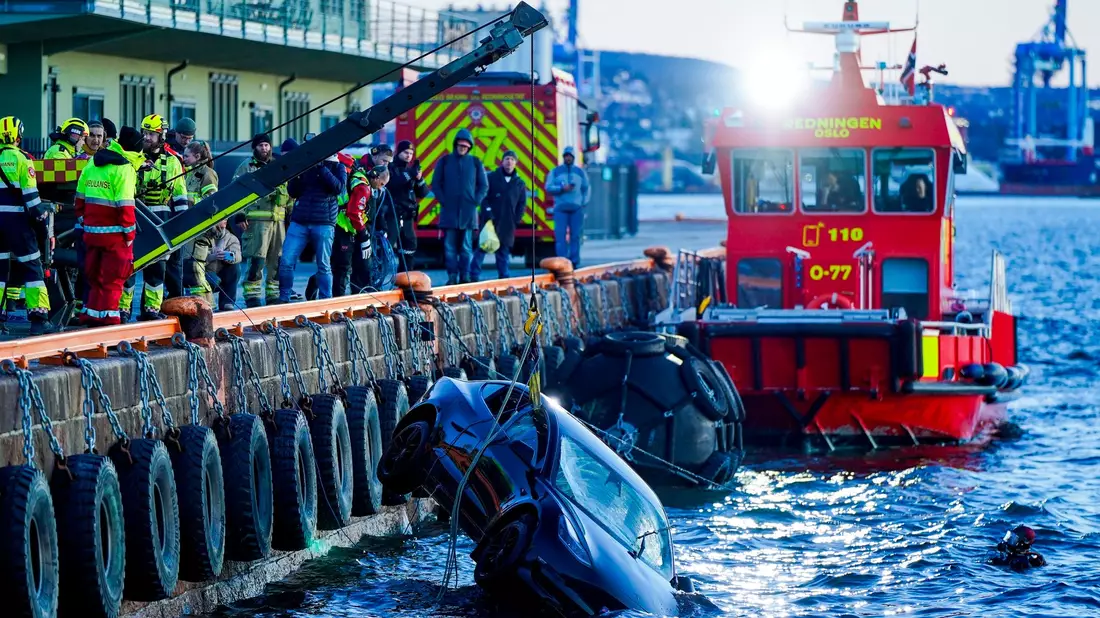 Feuerwehrleute bergen das versunkene Auto aus dem Fjord. - Bild: Håkon Mosvold Larsen/NTB/dpa