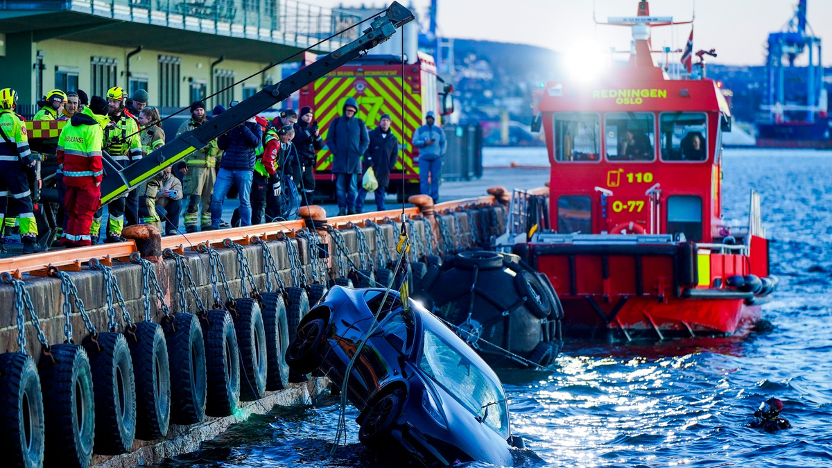 Feuerwehrleute bergen das versunkene Auto aus dem Fjord. - Foto: Håkon Mosvold Larsen/NTB/dpa