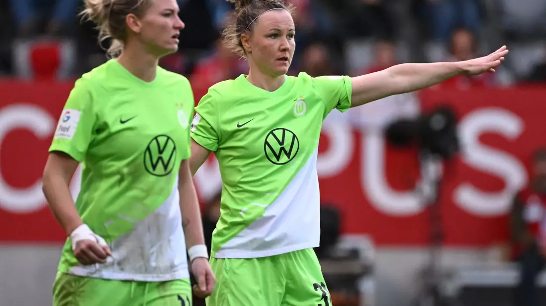 Wolfsburgs Alexandra Popp (r) und Marina Hegering am Spielfeld. - Bild: Angelika Warmuth/dpa