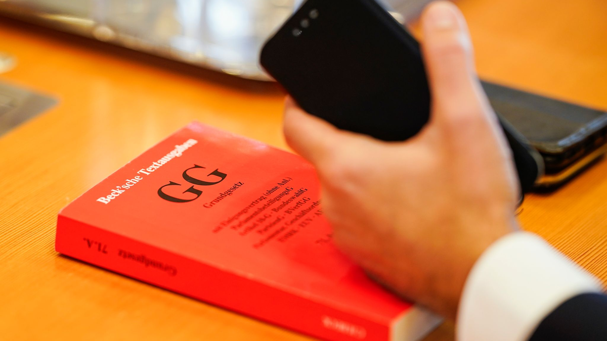 Ein Grundgesetz liegt im Verhandlungssaal des Bundesverfassungsgerichts auf einem Tisch. Eine Mehrheit der Deutschen sieht einer Umfrage zufolge die Demokratie in Deutschland in Gefahr. - Foto: Uwe Anspach/dpa