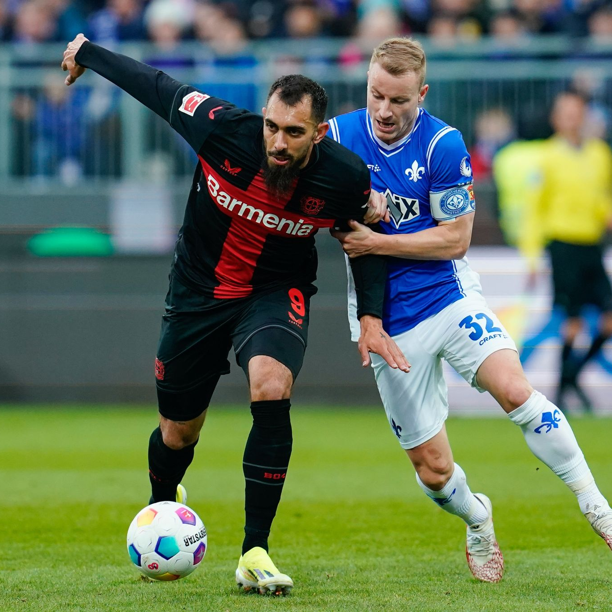 Darmstadt bemüht sich gegen Leverkusen: Fabian Holland (r.) im Duell gegen Leverkusens Borja Iglesias. - Foto: Uwe Anspach/dpa
