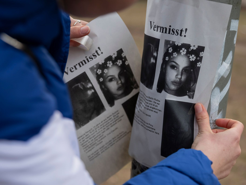 Ein junges Mädchen klebt Flugblätter an einen Laternenpfahl. - Foto: Christoph Soeder/dpa