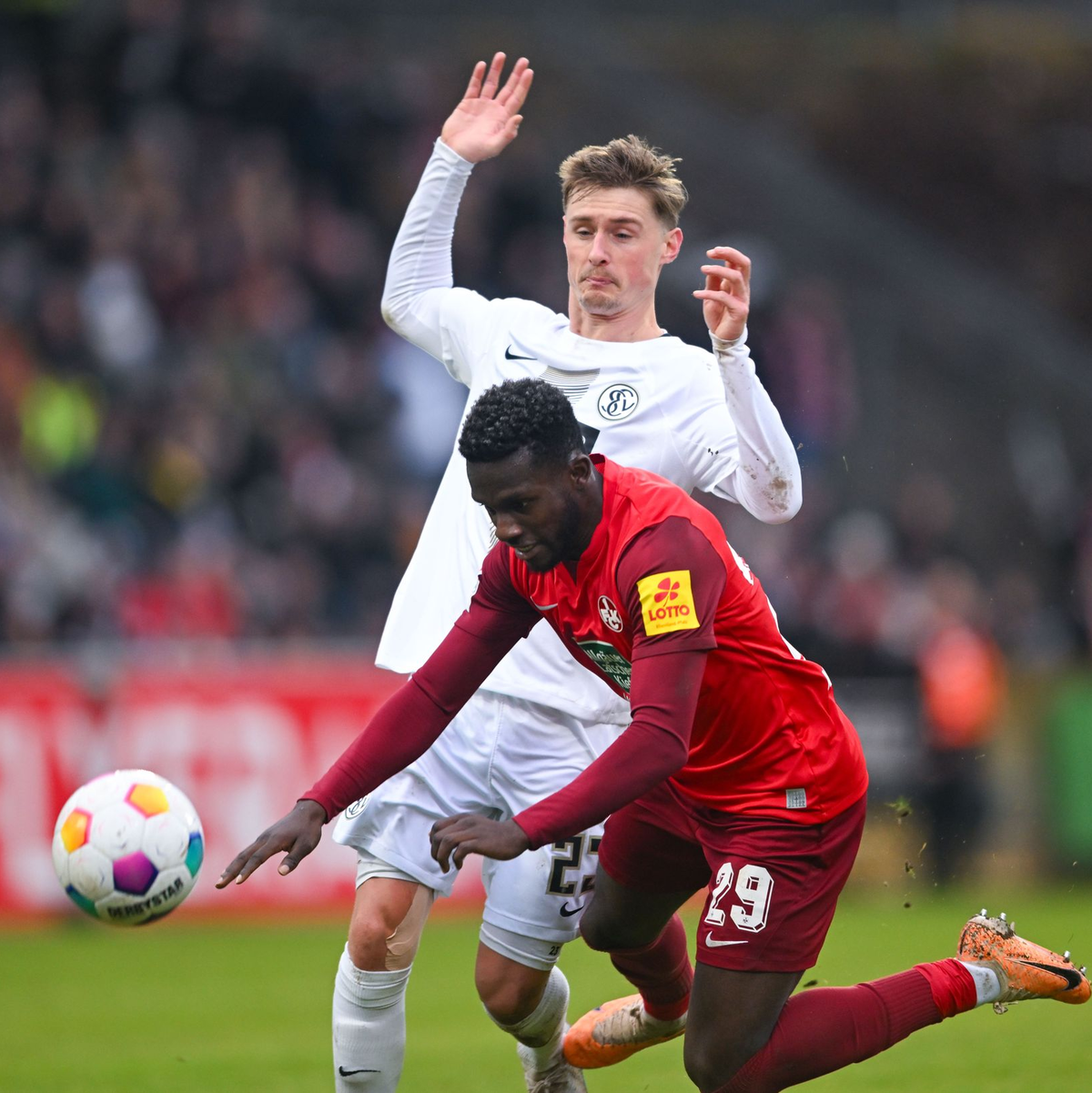 Der Elversberger Carlo Sickinger bringt Kaiserslauterns Richmond Tachie zu Fall. - Foto: Silas Schueller/DeFodi Images/dpa