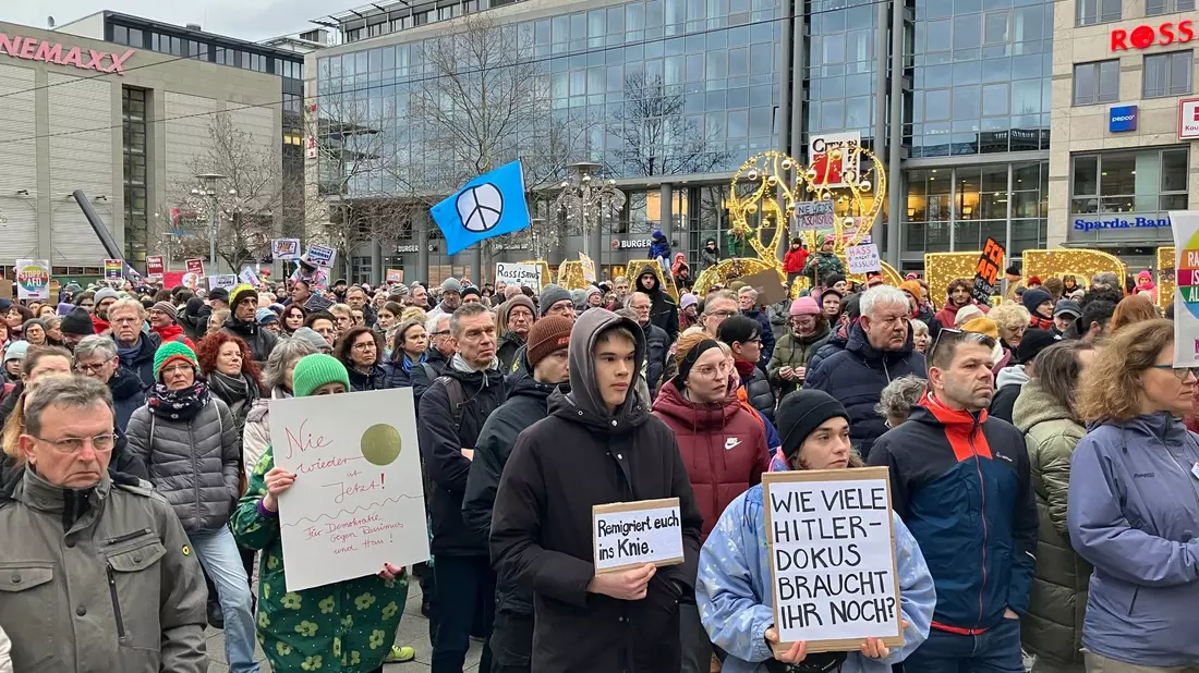 Demonstranten mit Plakaten vor dem Magdeburger Hauptbahnhof. - Bild: Simon Kremer/dpa