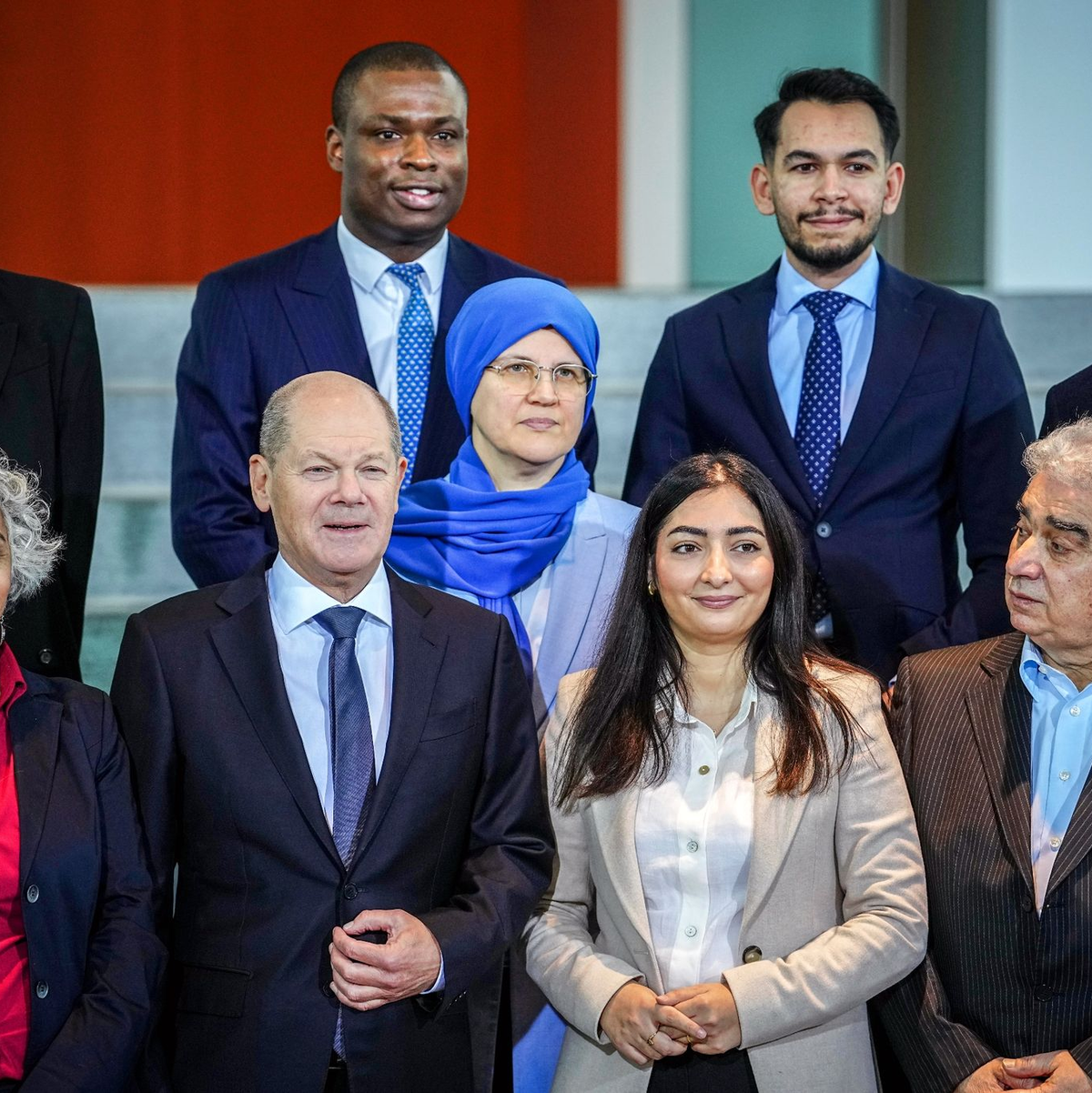 Olaf Scholz (erste Reihe, 2.v.l) und Reem Alabali-Radovan (2.v.r) nehmen am Treffen mit Vertreterinnen und Vertretern von Migrantenorganisationen sowie Netzwerken von Menschen mit Einwanderungsgeschichte teil. - Foto: Kay Nietfeld/dpa