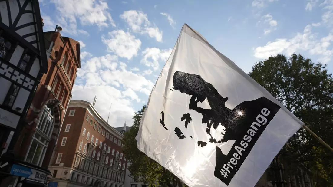 Eine Fahne mit dem Konterfei von Julian Assange wird bei einer Demonstration vor dem Royal Courts of Justice in London geschwenkt. - Bild: Jeff Moore/PA Wire/dpa