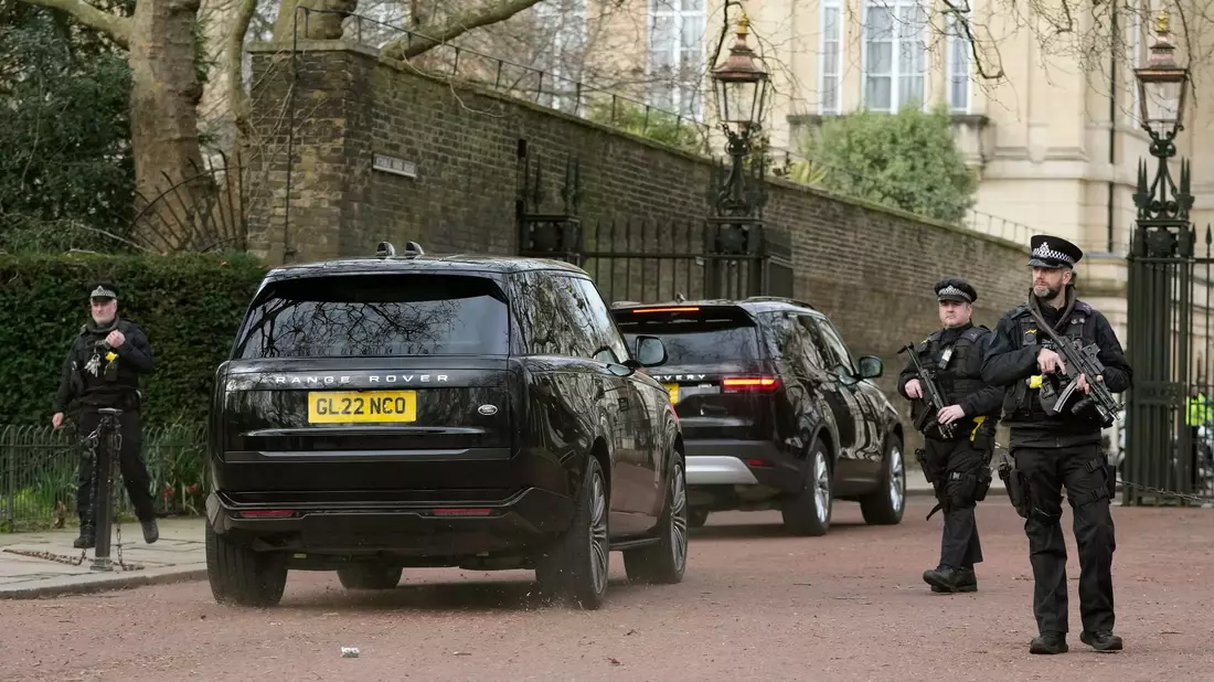 Zwei schwarze Geländewagen treffen im Clarence House ein. - Bild: Kin Cheung/AP