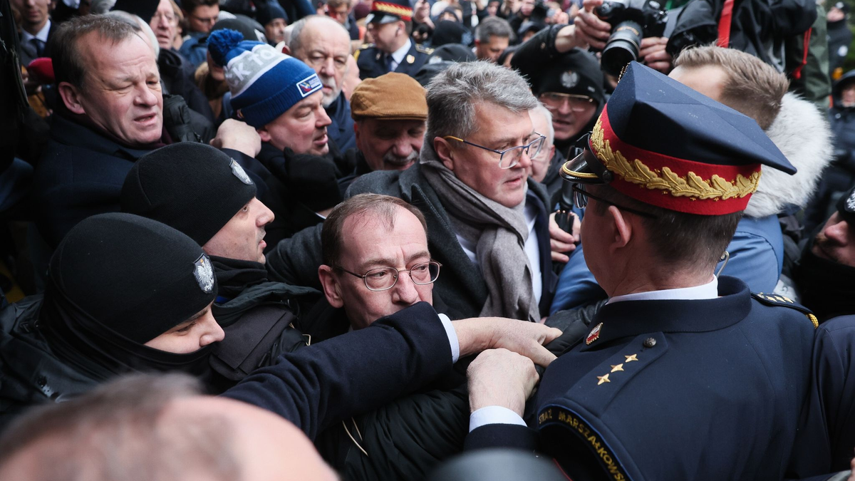 Müssen draußen bleiben: Mariusz Kaminski (M.) und Maciej Wasik (M., hinten) vor dem polnischen Parlamentsgebäude. - Foto: Leszek Szymanski/PAP/dpa