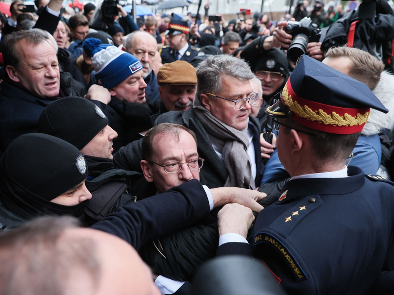 Müssen draußen bleiben: Mariusz Kaminski (M.) und Maciej Wasik (M., hinten) vor dem polnischen Parlamentsgebäude. - Foto: Leszek Szymanski/PAP/dpa