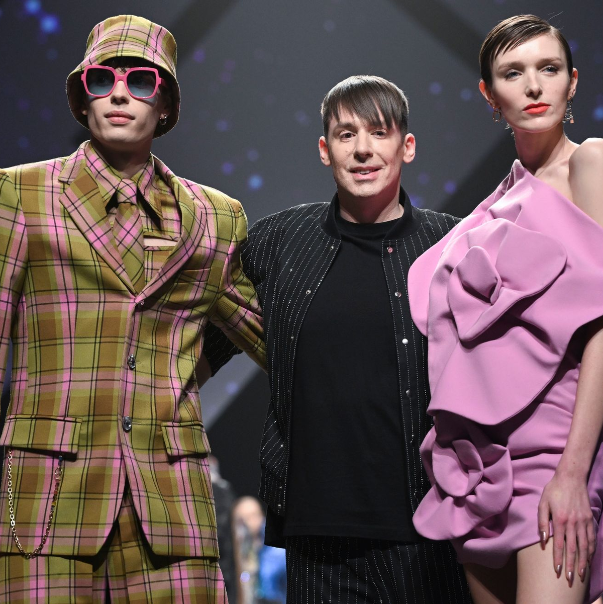 Designer Kilian Kerner (Mitte) mit Models bei seiner Show in der Verti Music Hall in Berlin. - Foto: Jens Kalaene/dpa