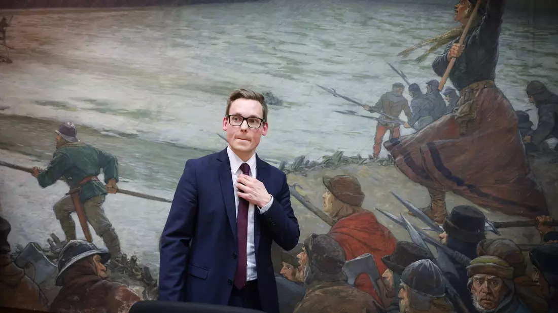 Thorben Schütt im Kreistagssaal von Heide vor dem Ölbild «Die Schlacht bei Hemmingstedt - anno 1500» (Max Friedrich Koch - 1859-1930). - Bild: Christian Charisius/dpa
