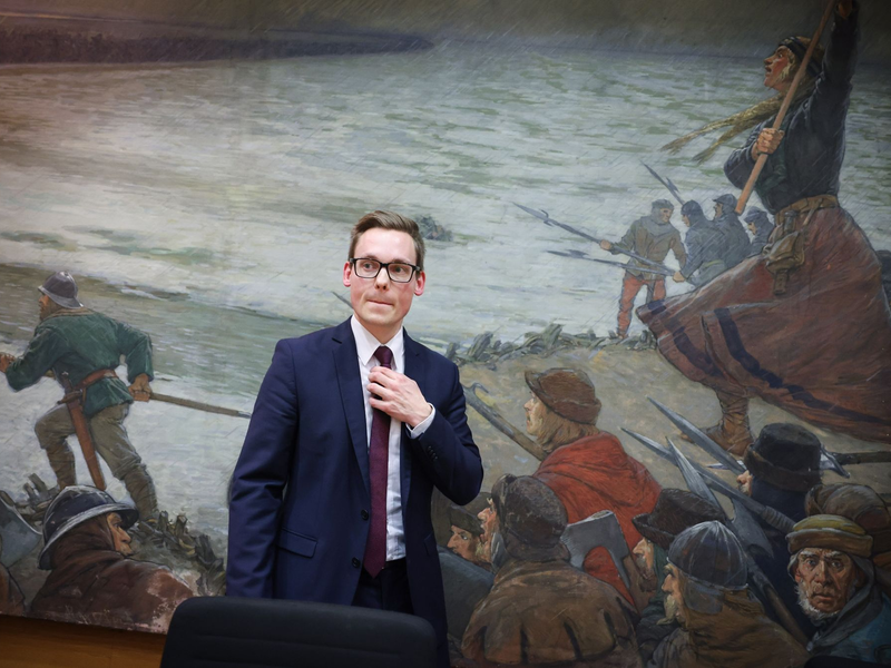 Thorben Schütt im Kreistagssaal von Heide vor dem Ölbild «Die Schlacht bei Hemmingstedt - anno 1500» (Max Friedrich Koch - 1859-1930). - Foto: Christian Charisius/dpa