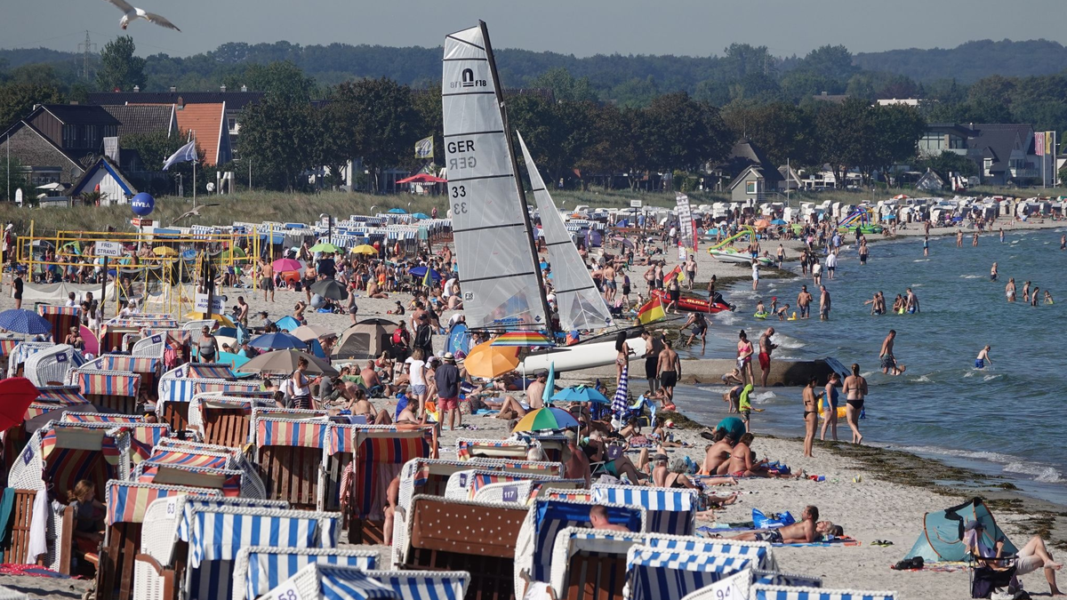 Menschen genießen das Sonnenwetter am Strand der Ostsee. - Foto: Franziska Spiecker/dpa