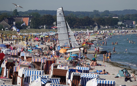 Menschen genießen das Sonnenwetter am Strand der Ostsee. - Foto: Franziska Spiecker/dpa