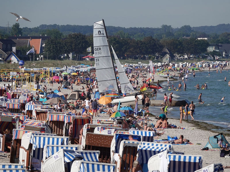 Menschen genießen das Sonnenwetter am Strand der Ostsee. - Foto: Franziska Spiecker/dpa