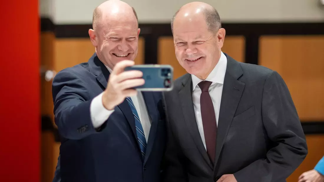 Mit einem herzhaften Lachen: Olaf Scholz (r) und Chris Coons machen ein Selfie. - Bild: -/Bundesregierung/dpa