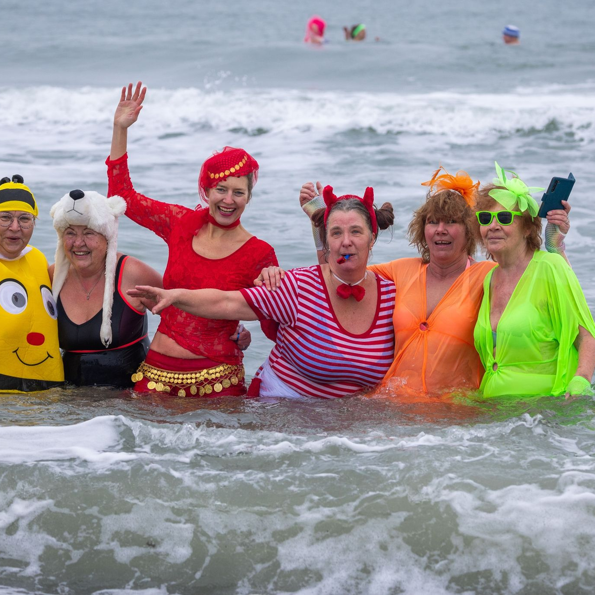 Kostümierte Eisbader vergnügen sich beim Faschingsbaden am Strand von Warnemünde in der 3,8 Grad kalten Ostsee. - Foto: Jens Büttner/dpa