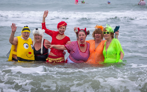 Kostümierte Eisbader vergnügen sich beim Faschingsbaden am Strand von Warnemünde in der 3,8 Grad kalten Ostsee. - Foto: Jens Büttner/dpa