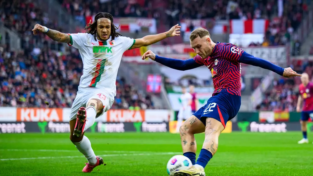 RB-Profi David Raum (r) flankt gegen den Augsburger Kevin Mbabu. - Bild: Tom Weller/dpa