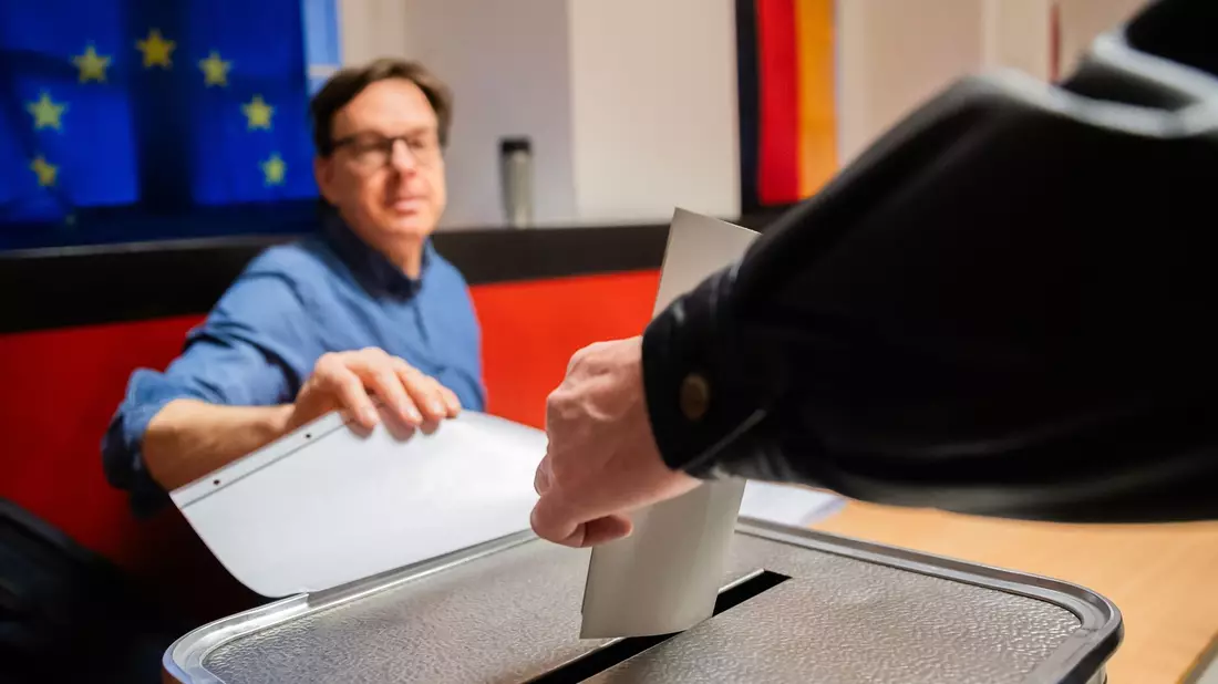 Ein Wähler wirft in einem Wahllokal in Berlin-Pankow den Wahlzettel in die Urne. - Bild: Christoph Soeder/dpa