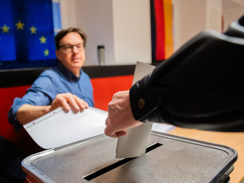 Ein Wähler wirft in einem Wahllokal in Berlin-Pankow den Wahlzettel in die Urne. - Foto: Christoph Soeder/dpa