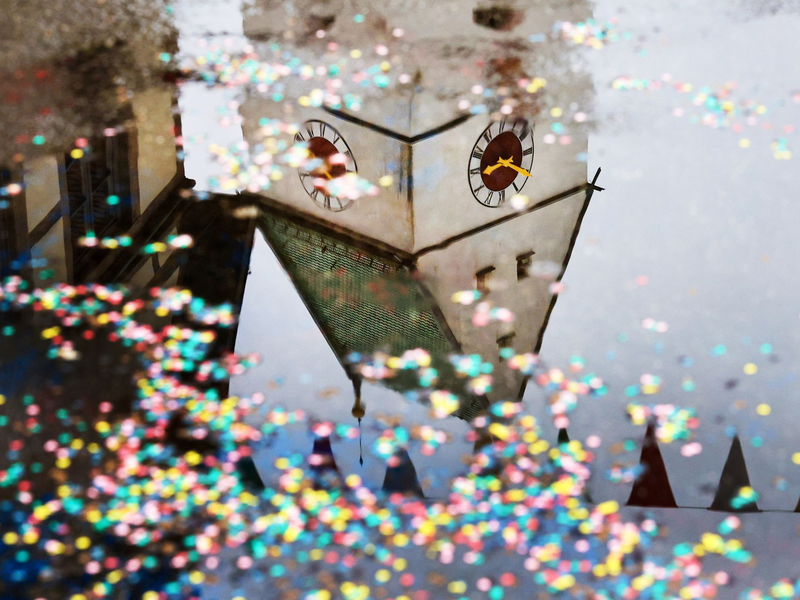 Der Kirchturm der Kirche St. Georg in Riedlingen in Baden-Württemberg spiegelt sich in einer Pfütze. - Foto: Thomas Warnack/dpa