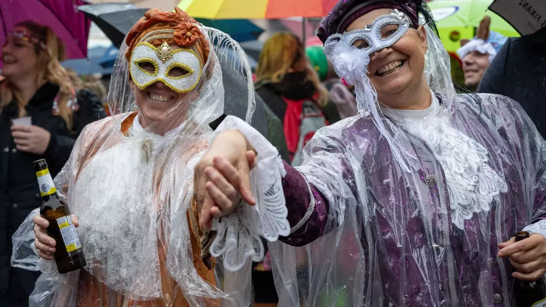 Narren auf dem Marktplatz in Wittlich an  Weiberfastnacht. Auch am Rosenmontag kann es nass werden. - Bild: Harald Tittel/dpa