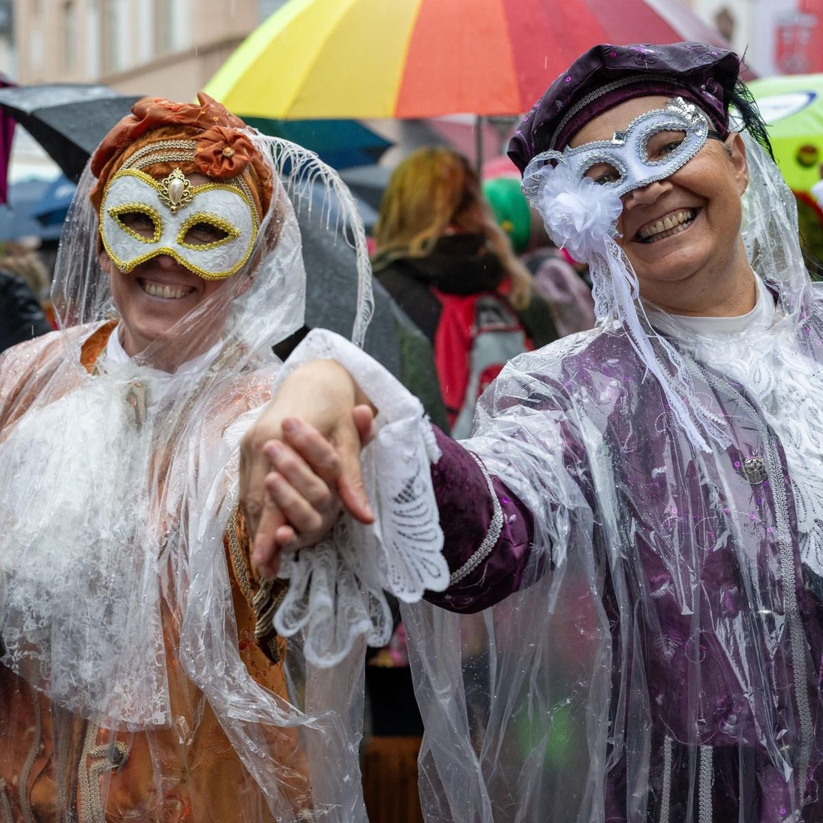 Narren auf dem Marktplatz in Wittlich an  Weiberfastnacht. Auch am Rosenmontag kann es nass werden. - Foto: Harald Tittel/dpa