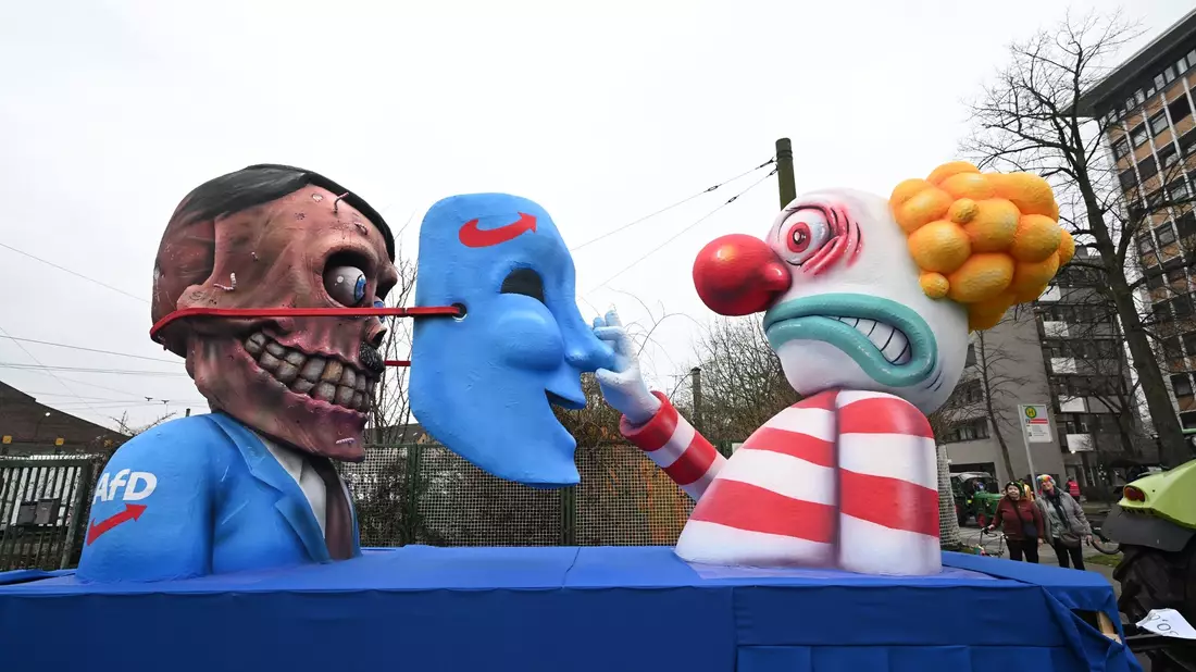 «Sahras neuer Wagenknecht» steht auf dem Umhang einer Figur auf einem Mottowagen beim Rosenmontagszug in Düsseldorf. - Bild: Federico Gambarini/dpa
